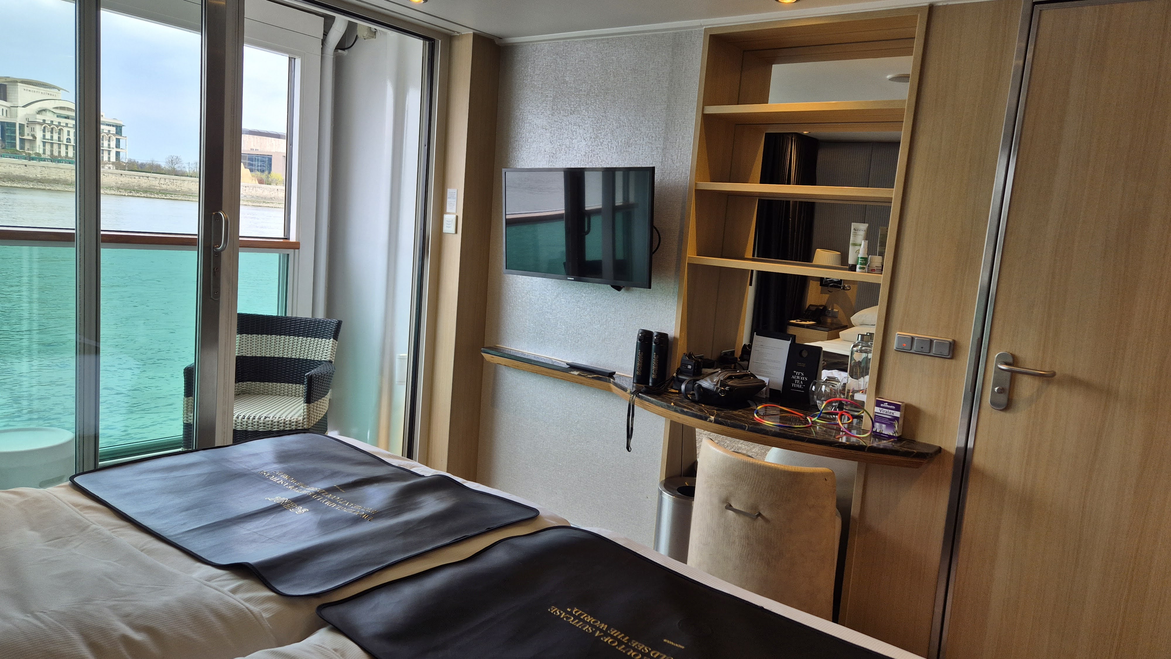 Built-in shelving, desk and wardrobe storage in a Scenic Crystal Balcony Suite