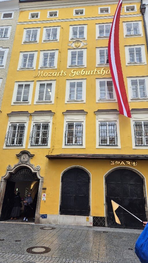 The yellow façade of Mozart's birthplace in Salzburg with an Austrian flag