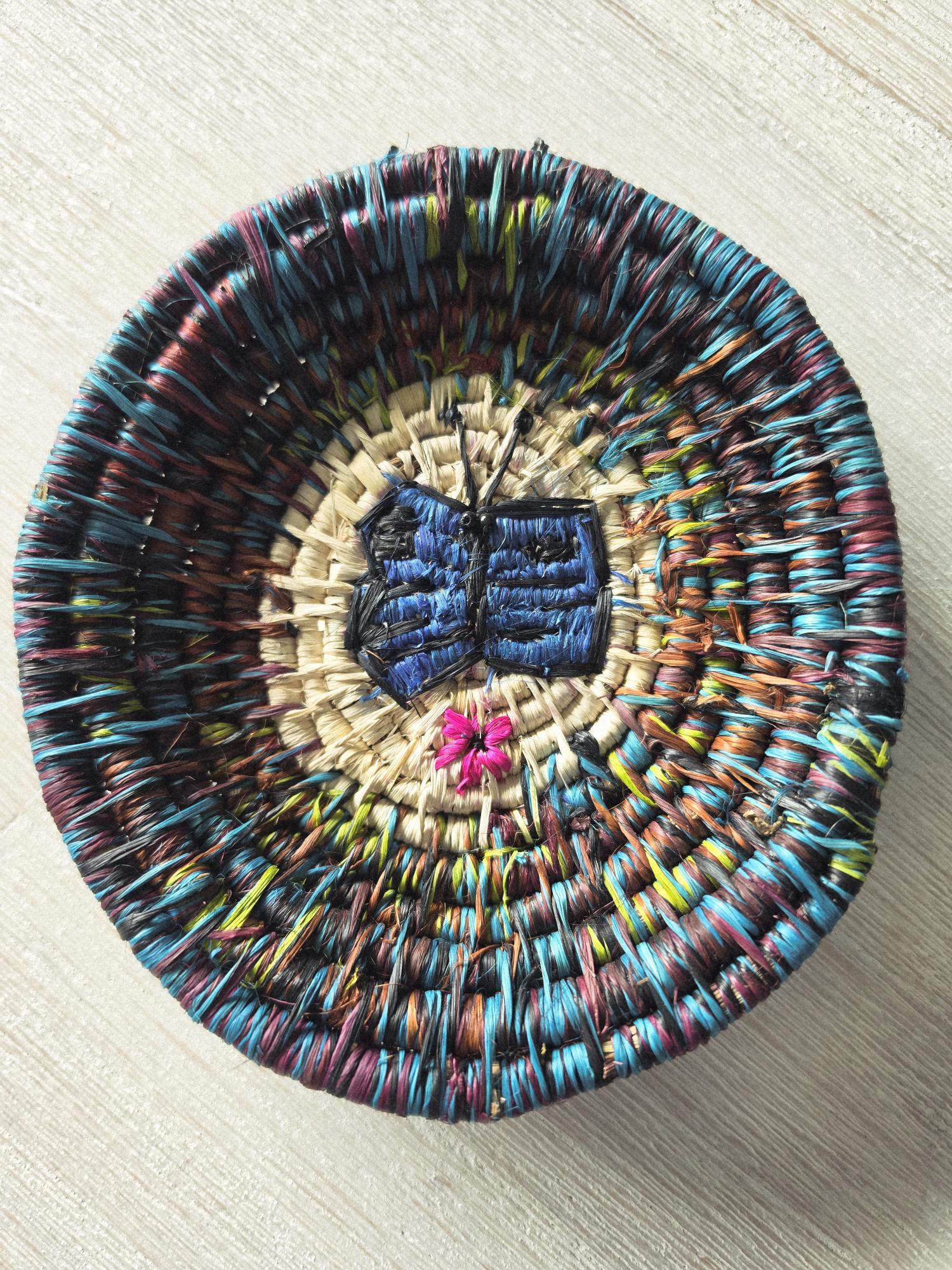 A woven chambira plate with a blue morpho butterfly, bought at San Francisco village